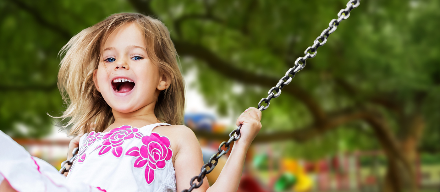Young girl on swings after visiting pediatric dentist in Independence