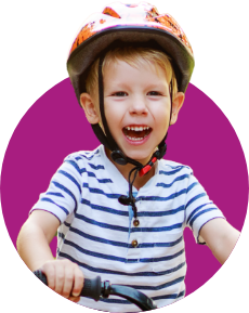 Young boy wearing bicycle helmet and sitting on bicycle