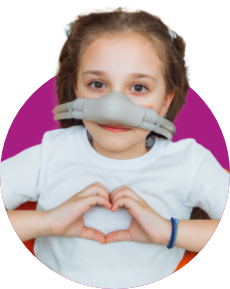 Young girl with nitrous oxide sedation mask on making heart shape with her hands