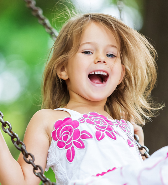 Smiling little girl swinging