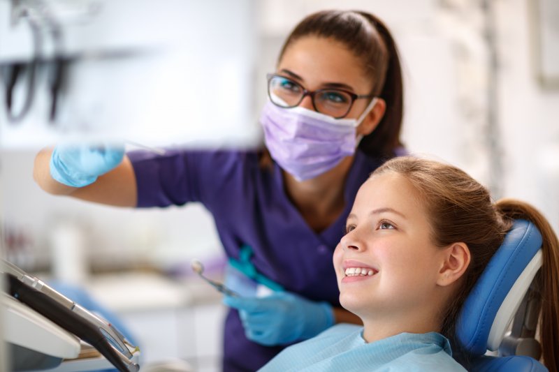 A dentist preparing her young patient for sedation dentistry