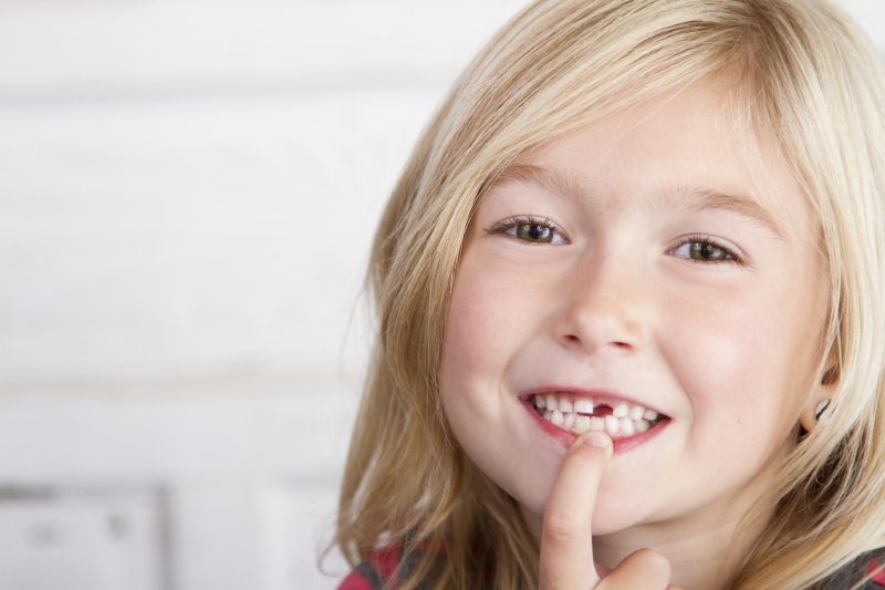 Child smiling with missing tooth